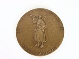 an old bronze coin with a woman holding a trumpet