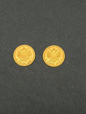 deux pièces d'or posées sur une surface noire