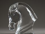 un gros plan sur une tête de cheval en verre posée sur une table