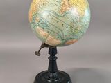 a small globe that is on a stand on a table