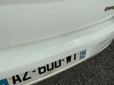 un gros plan d'une voiture blanche sur laquelle est collé un autocollant