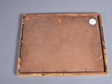 an old wooden picture frame with a white button on it