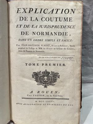 un livre ouvert posé sur une table, à côté d'une nappe blanche