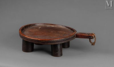 an old wooden tray with a handle on a gray surface