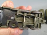 a person holding a toy army vehicle in their hand