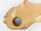 a brown object with a hole in it on a white surface