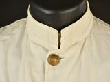 a close up of a white shirt with a button on the collar