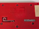 a close up of a red electronic device on a table