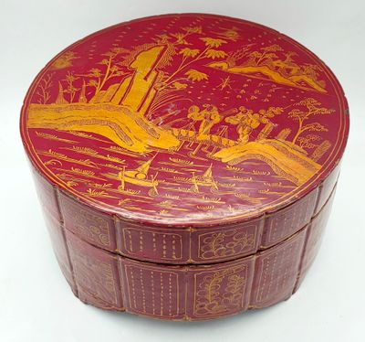 une boîte rouge ornée d'une peinture, posée sur une table