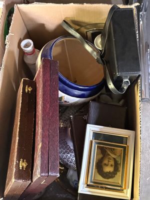 une boîte remplie d'objets divers, parmi lesquels figure la photo d'un homme portant un chapeau
