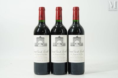 trois bouteilles de vin rouge posées côte à côte sur une table