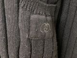 the back of a gray sweater with a button on it