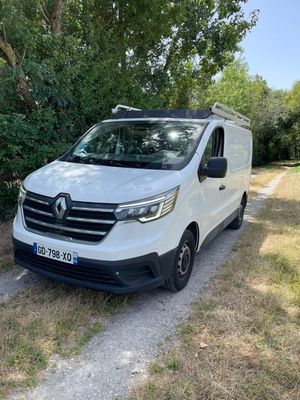 une camionnette blanche garée sur le bord d'un chemin de terre
