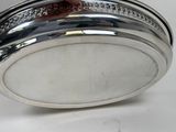 someone is holding a silver plate with a diamond pattern on it