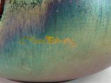 a close up of a vase on a white surface