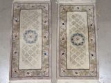 une paire de tapis orientaux à franges posés sur un sol blanc