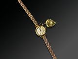 an image of a gold wrist watch with a pen and a clock on it