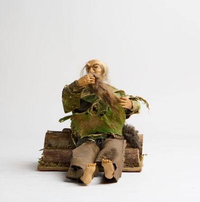 une figurine représentant un homme assis sur une pile de livres