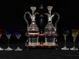 Plusieurs verres à vin et une carafe sont alignés sur une table