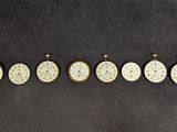 Plusieurs horloges sont disposées en rangée sur une surface noire