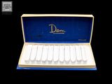 une boîte contenant six paires de chaussures blanches