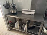 une cuisine équipée d'un plan de travail en inox sur lequel est posé un mixeur