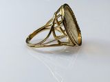 an image of a gold ring with a green stone in the center