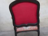 a red and black chair sitting in front of a white wall