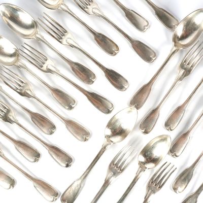 de nombreuses cuillères et fourchettes disposées ensemble sur une surface blanche
