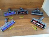 several vacuum cleaners are lined up on a wooden floor