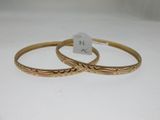 a pair of gold bangles with engraved designs on them