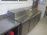 plans de travail en acier inoxydable dans une cuisine professionnelle dotée d'une fenêtre