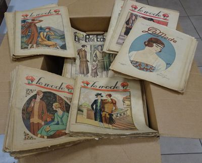 several books in a cardboard box on a tiled floor