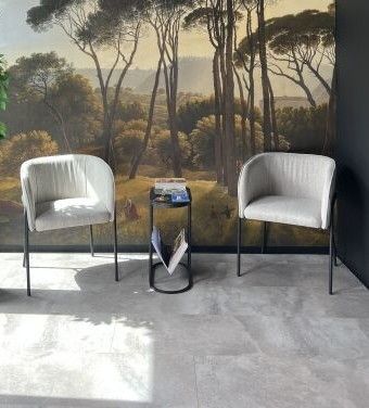 two chairs in front of a wall with a painting on it