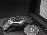 a watch sitting in a case with a medal