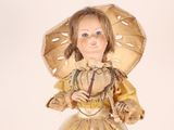 a doll that is wearing a yellow dress and a hat