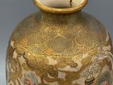 a gold vase with a picture of a dragon on it