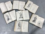 several open books on a table with a statue in the middle of them