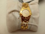 a gold wrist watch sitting on top of a white pillow