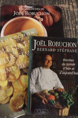 deux livres posés sur une table, à côté d'une tasse de thé et d'une assiette de nourriture