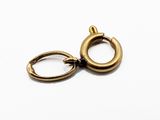 un gros plan sur une paire de boucles d'oreilles créoles en or posées sur une surface blanche