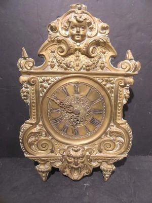 a gold clock with a face on the front of it