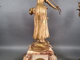 three bronze statues of a woman with a violin and a bird