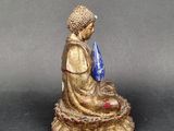 a small statue of a person sitting on a table