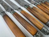 several knives are lined up in a row on a white surface