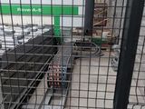 a picture of a metal cage with a green sign in the background