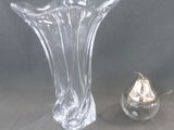 un vase en verre et un petit objet en argent posés sur une table