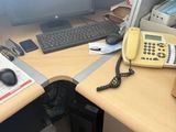 un bureau équipé d'un téléphone, d'un clavier et d'un écran