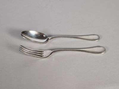 deux cuillères et une fourchette sur une table blanche