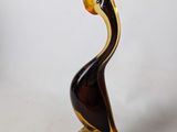 a glass sculpture of a bird sitting on a rock